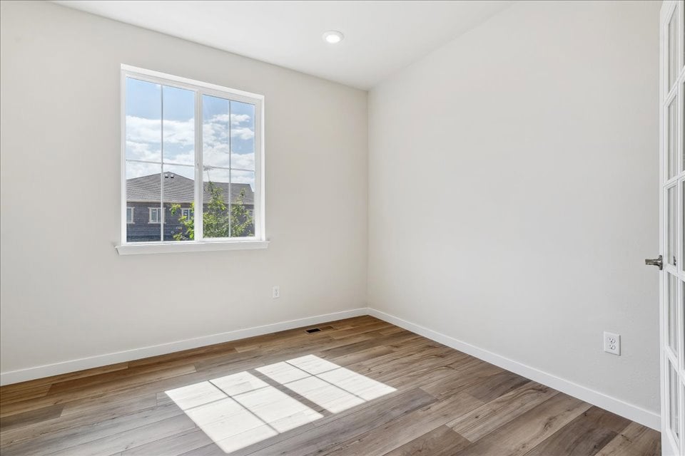 A room with a wood floor and windows.
