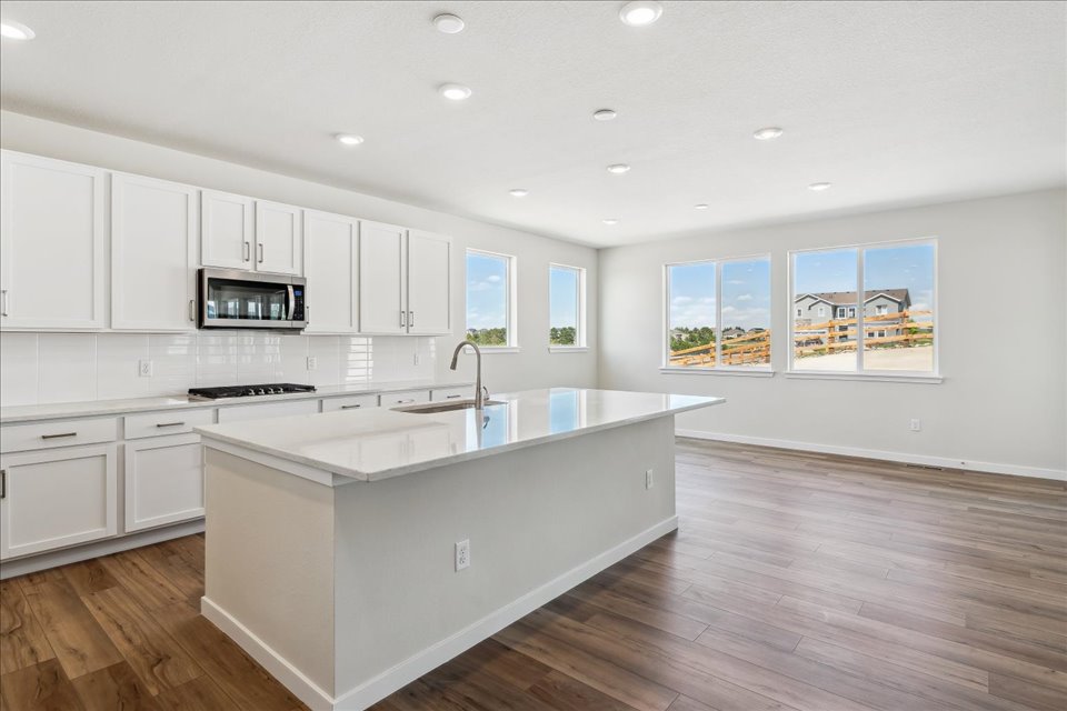 A kitchen with white cabinets.