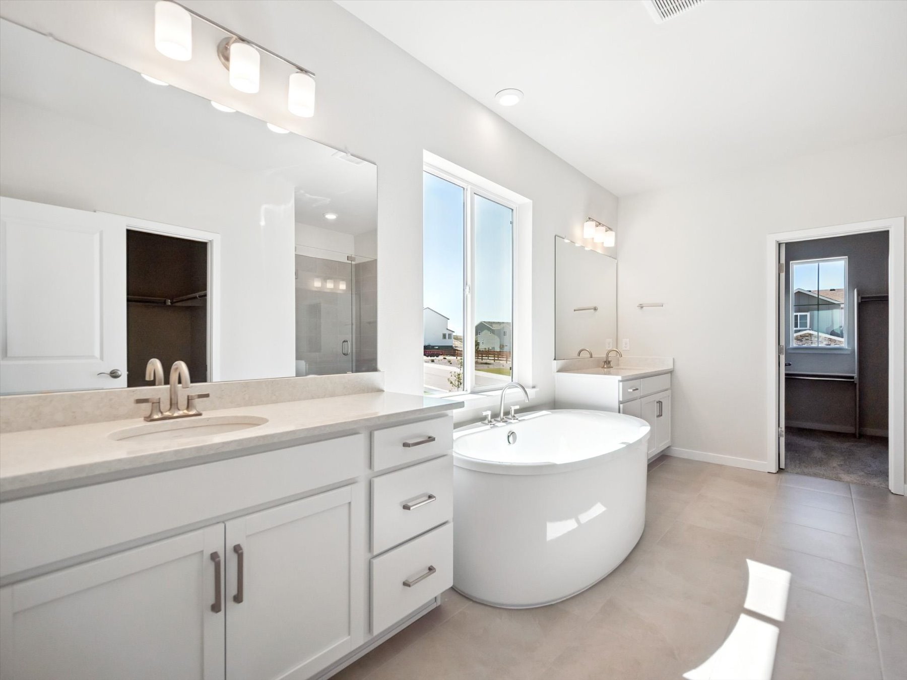 A bathroom with a tub sink and mirrors.