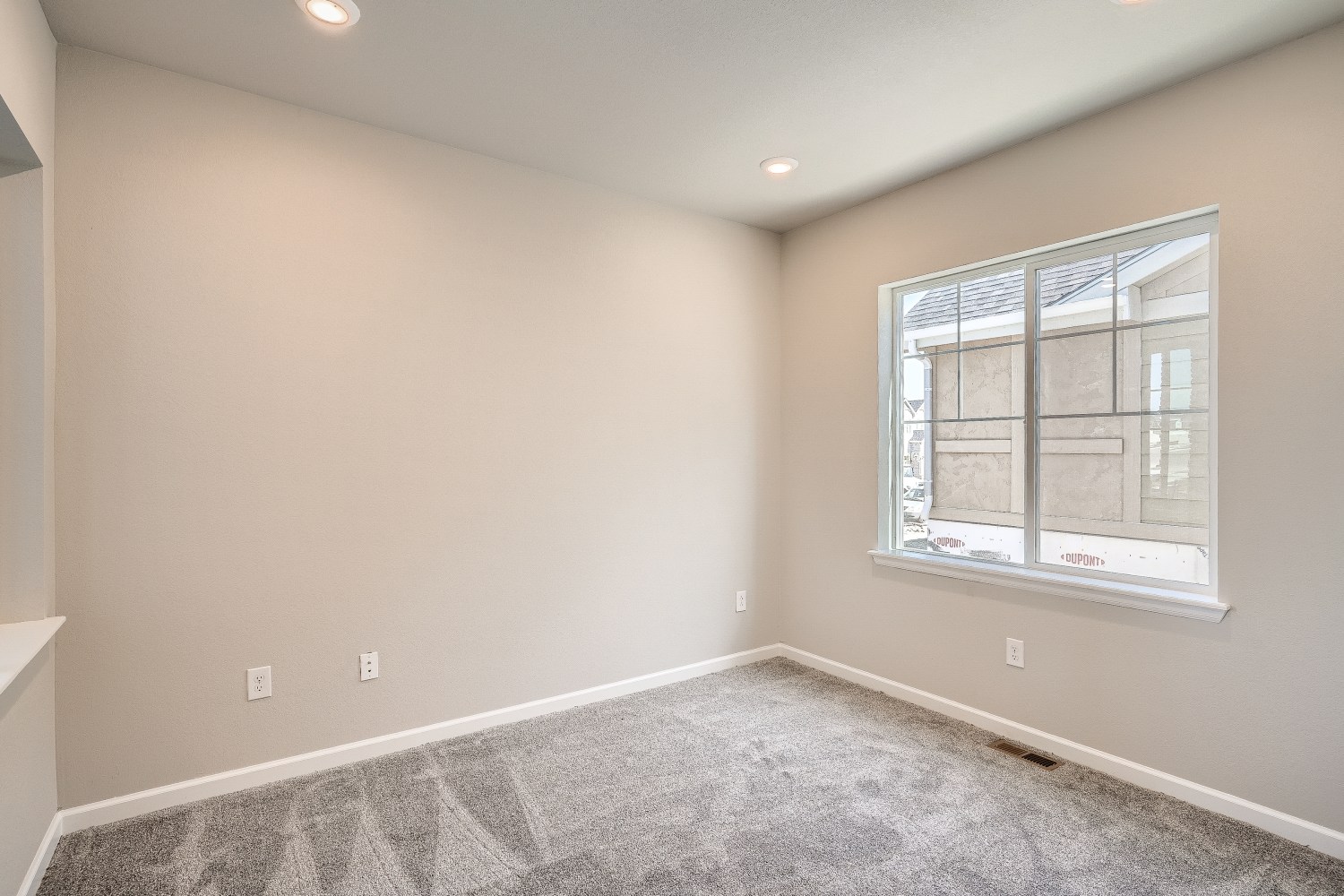 A room with a window and a carpet.