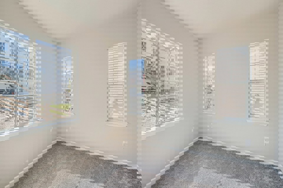 A room with windows and a carpet.