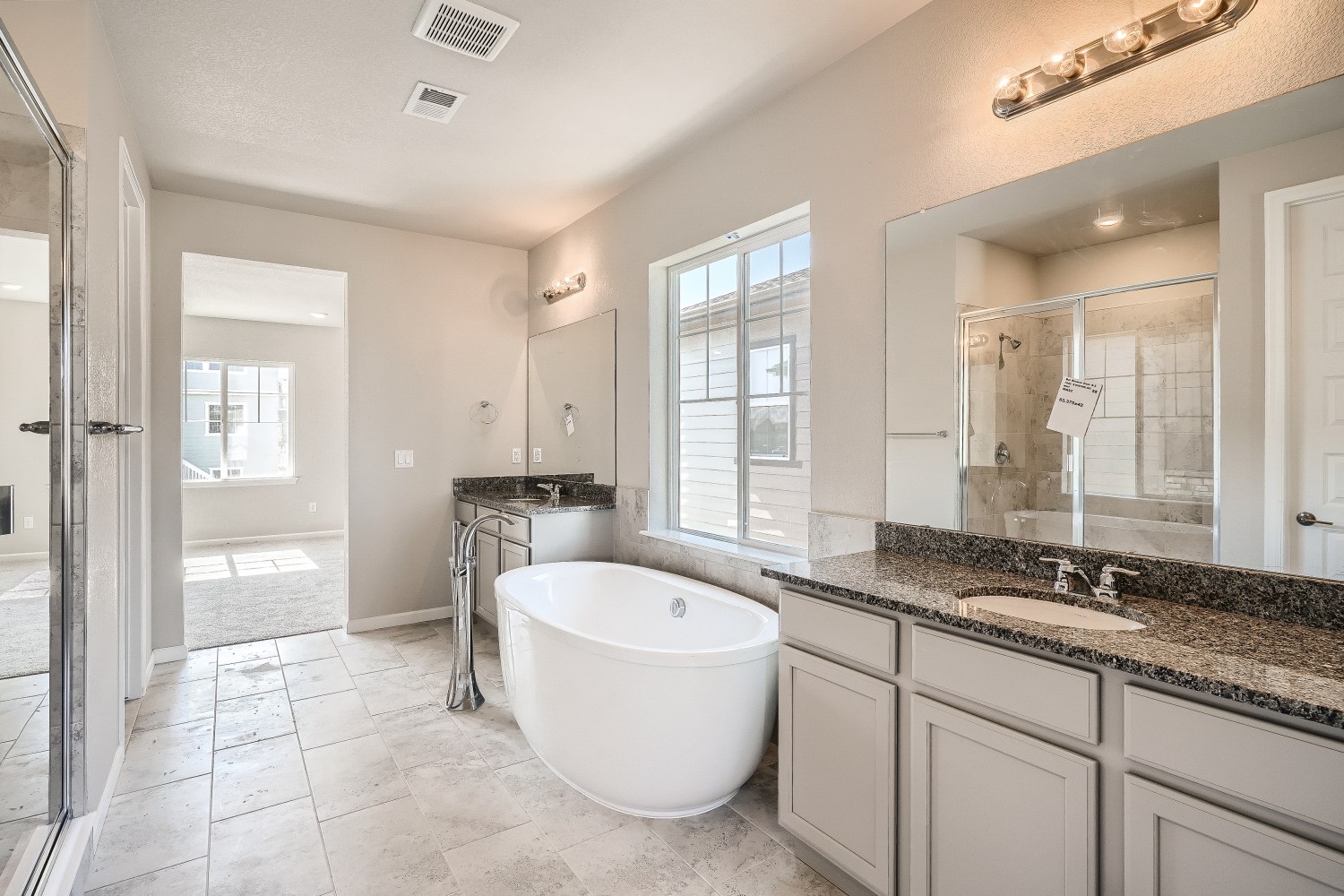 A bathroom with a tub sink and a mirror.