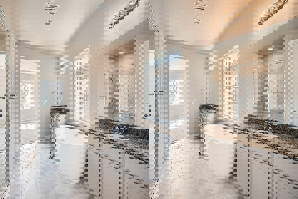 A bathroom with a tub sink and a mirror.