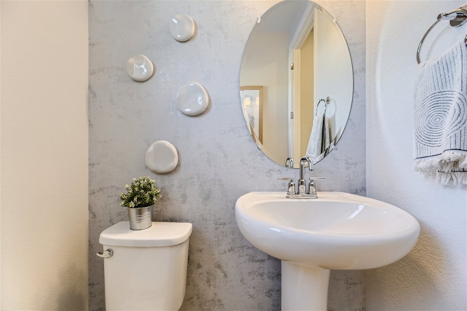 A bathroom with a round mirror.