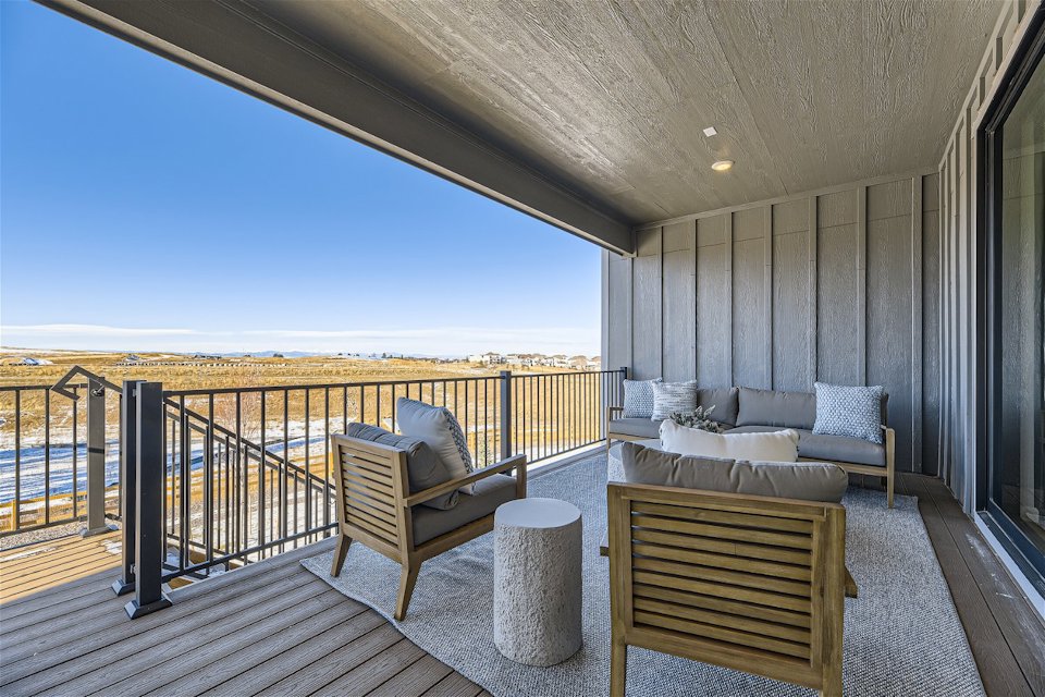 A deck with a couch and chairs.