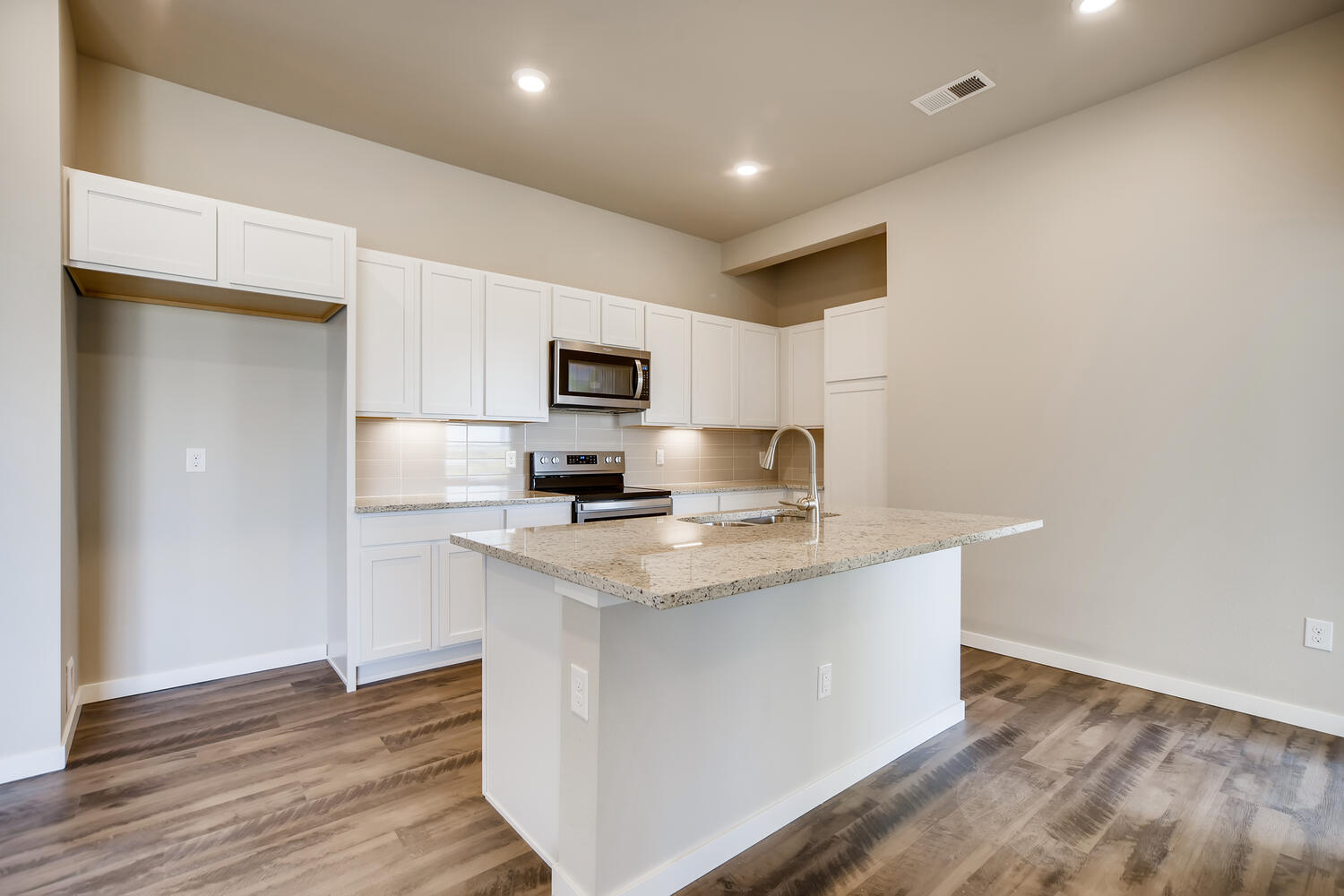 A kitchen with white cabinets.