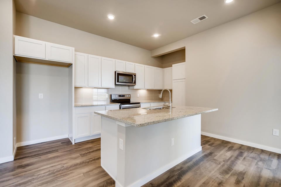 A kitchen with white cabinets.