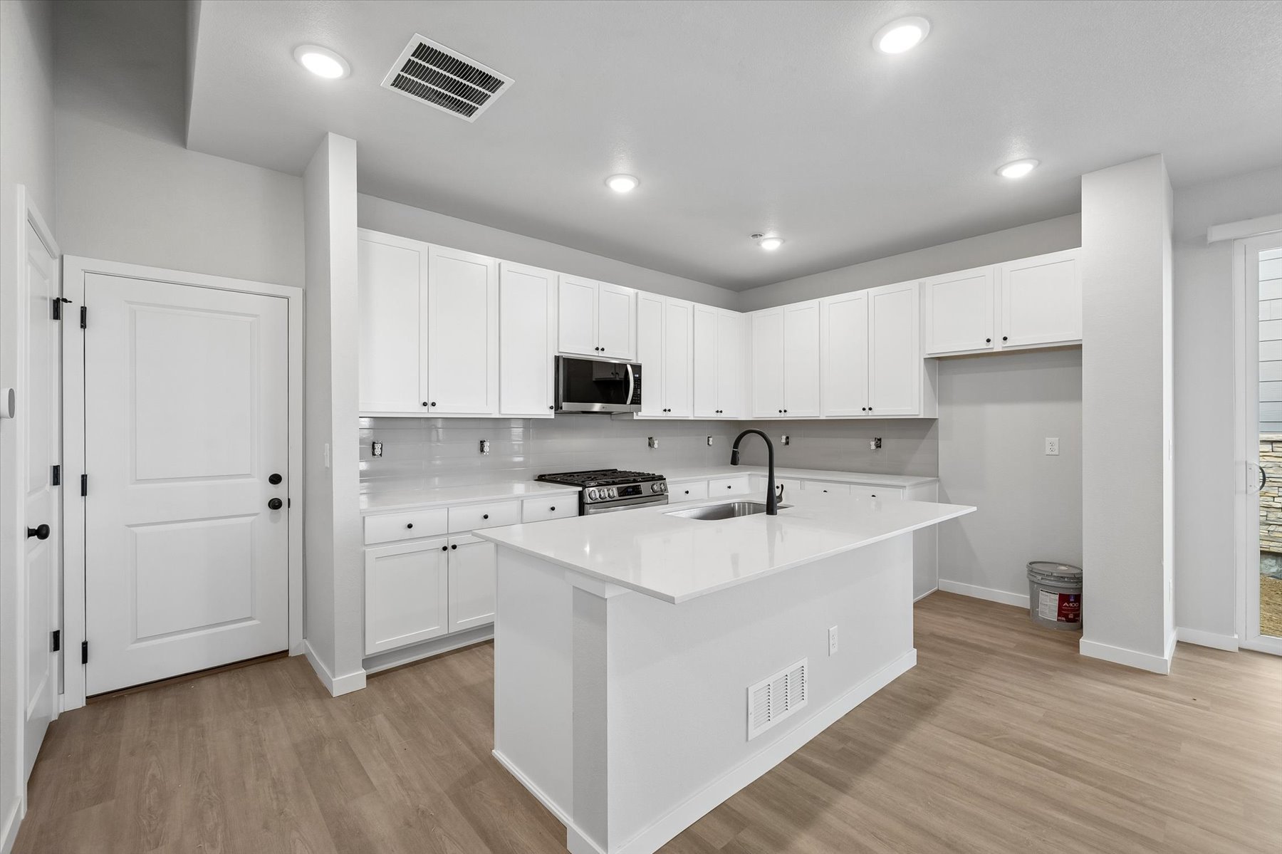A kitchen with white cabinets.