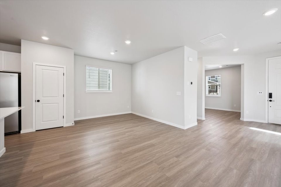 A room with white walls and wood floors.