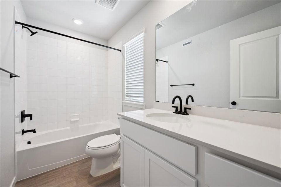 A bathroom with a tub toilet and sink.