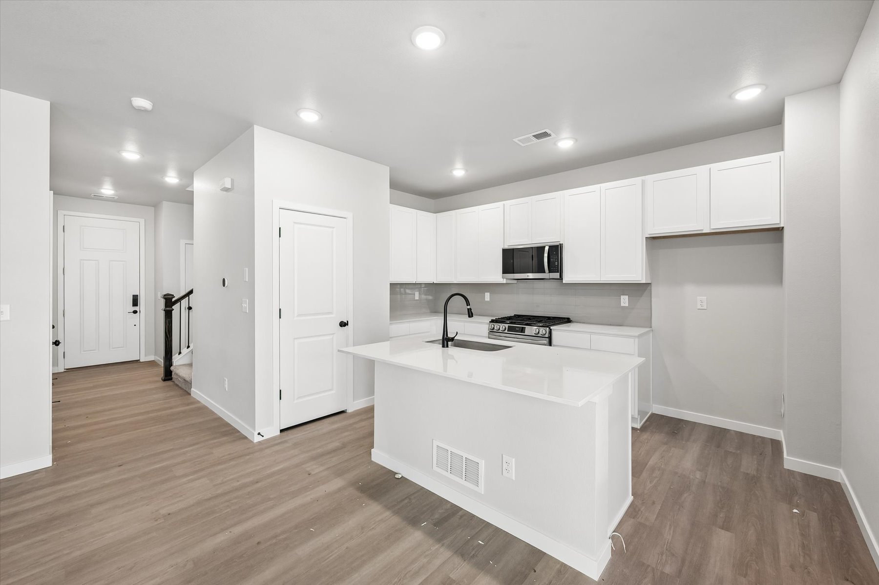 A kitchen with white cabinets.