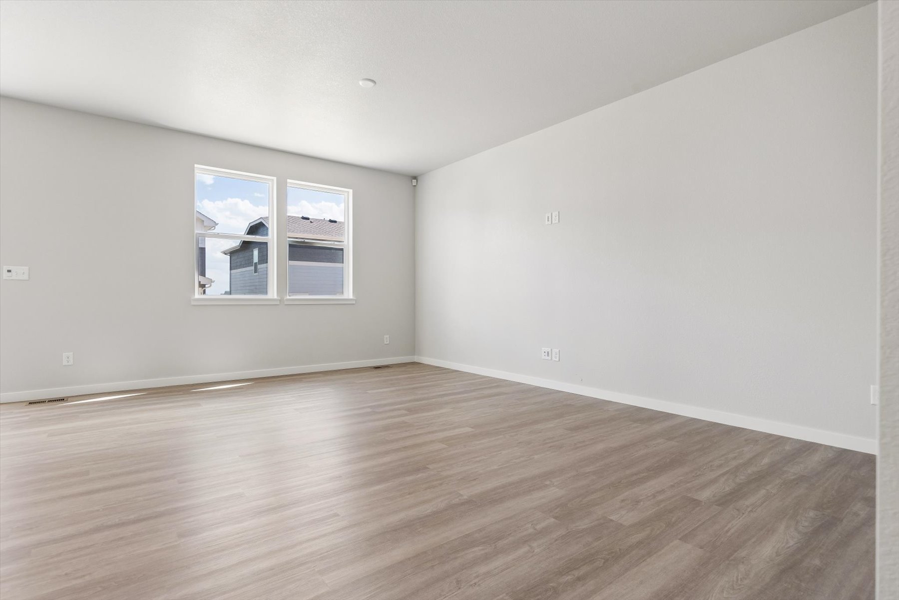 A room with a wood floor and a window.