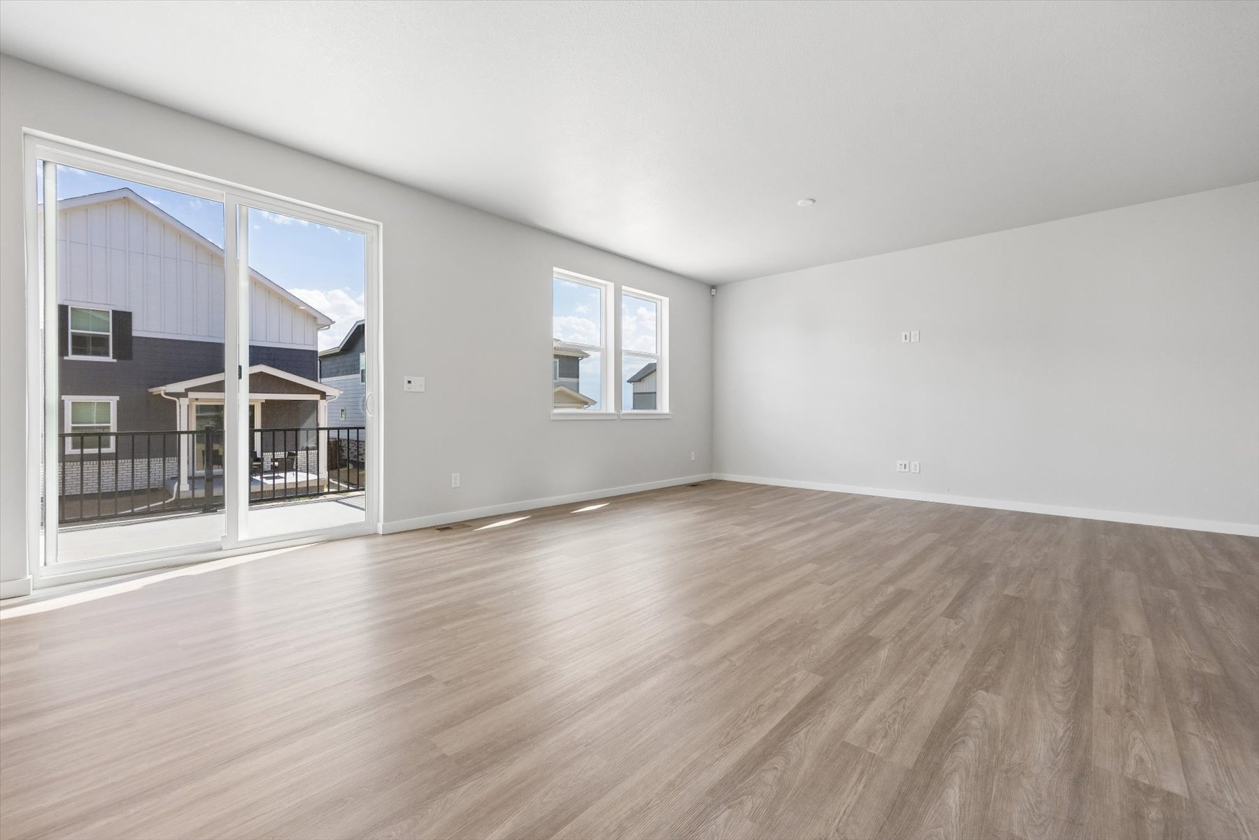 A room with a wood floor and a wood floor with a window.
