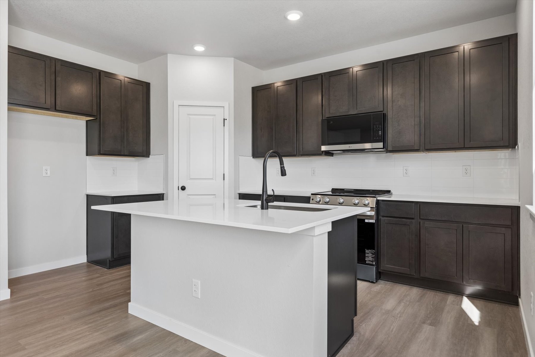A kitchen with black cabinets.