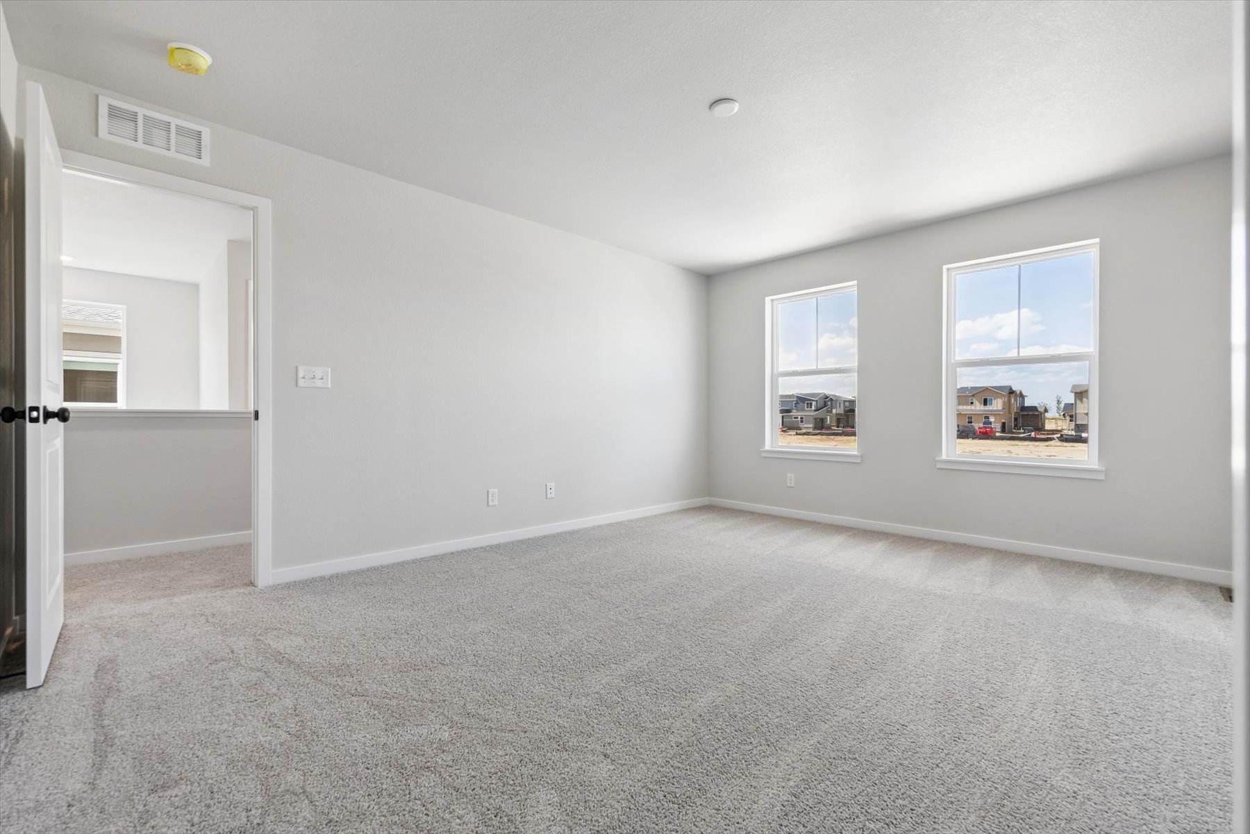 A room with a carpet and a window.