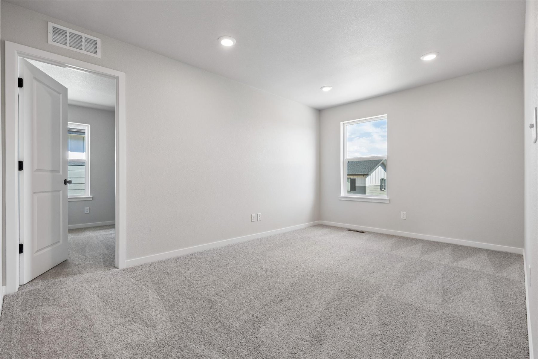 A room with a carpet and a window.