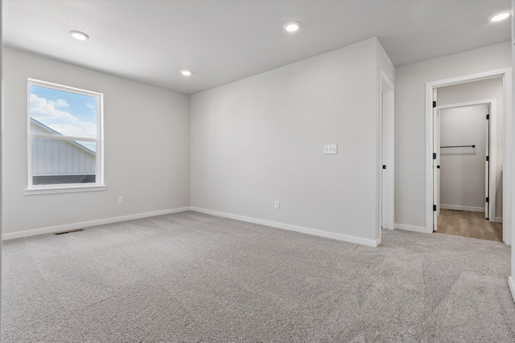 A room with a carpet and a door.