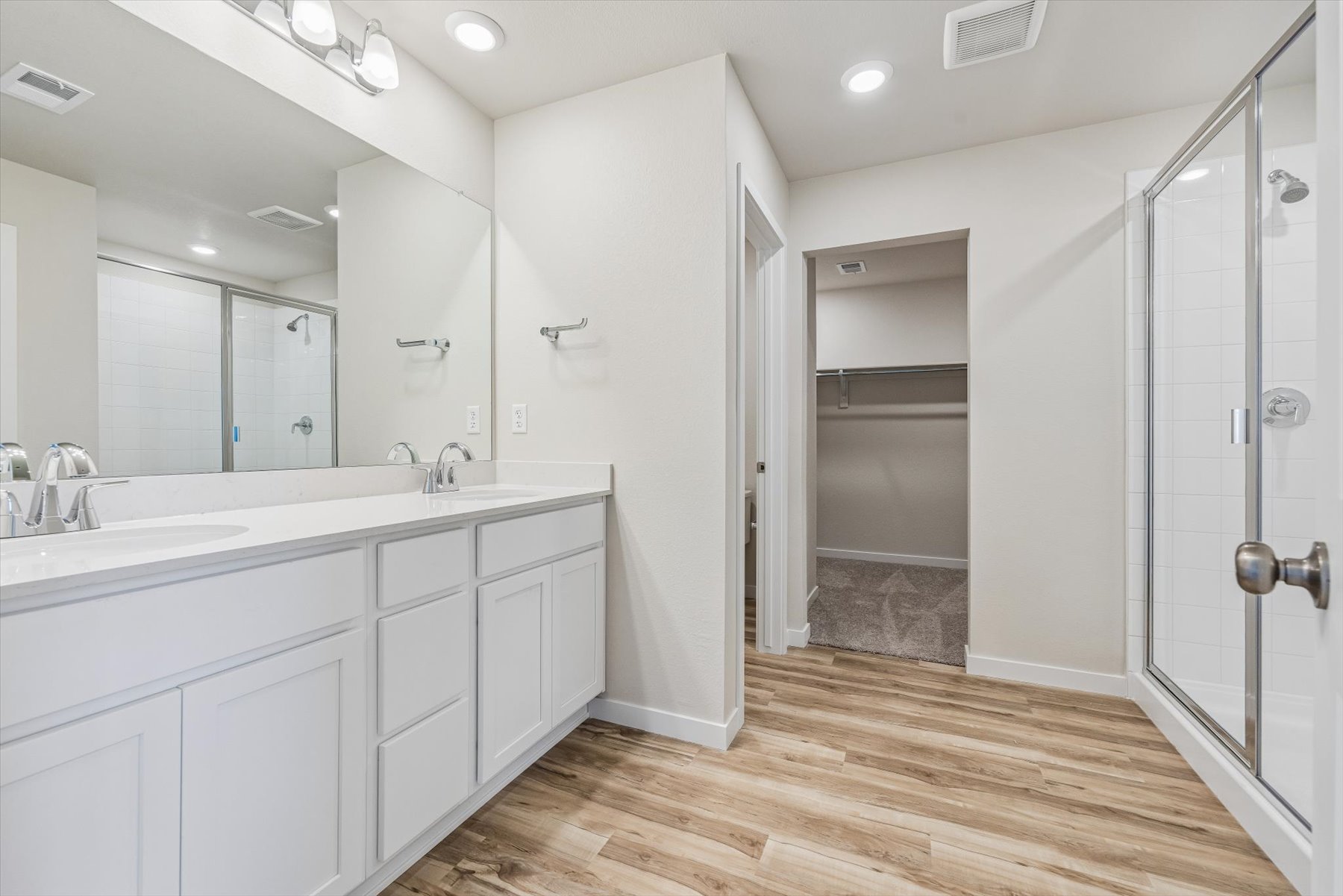 A bathroom with white cabinets.
