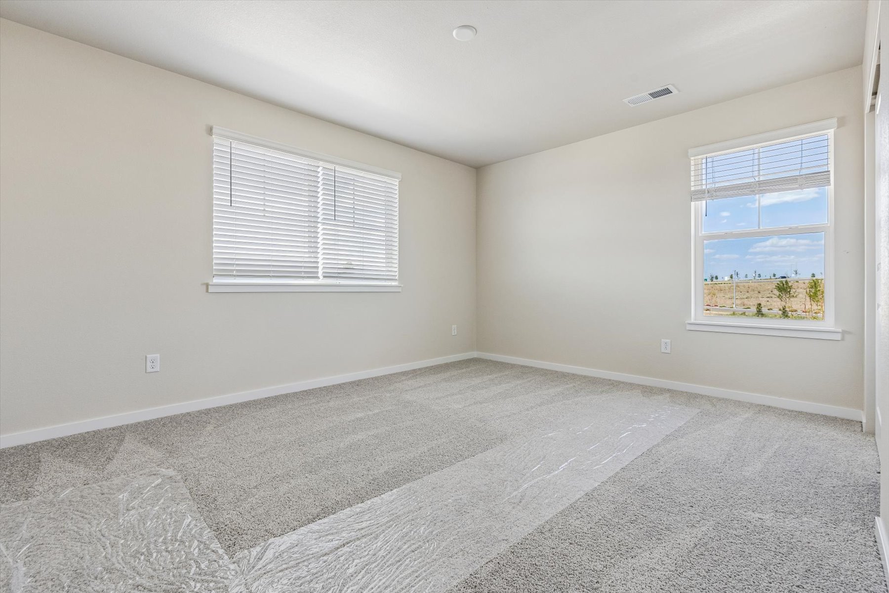 A room with a carpet and windows.
