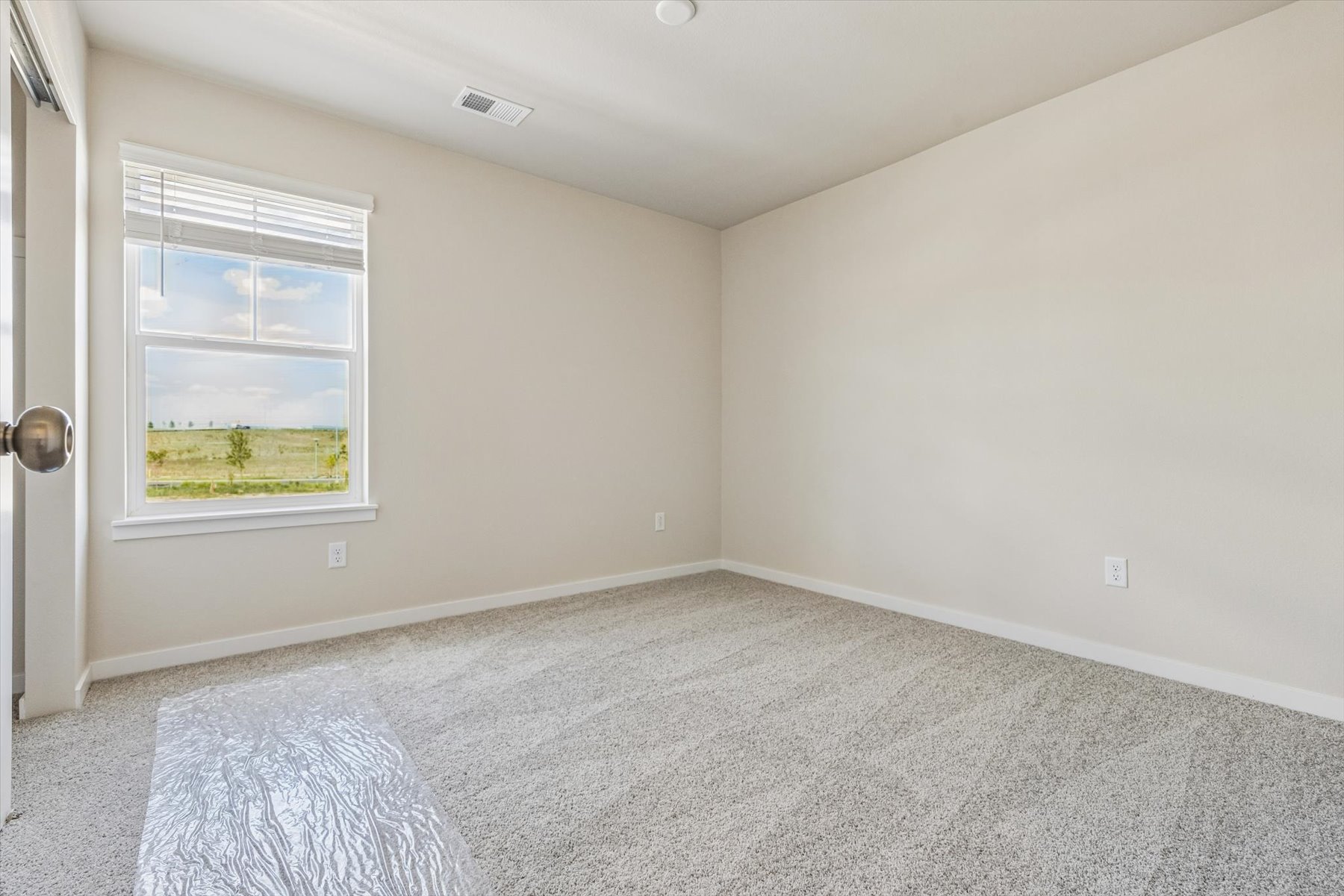 A room with a carpet and a window.