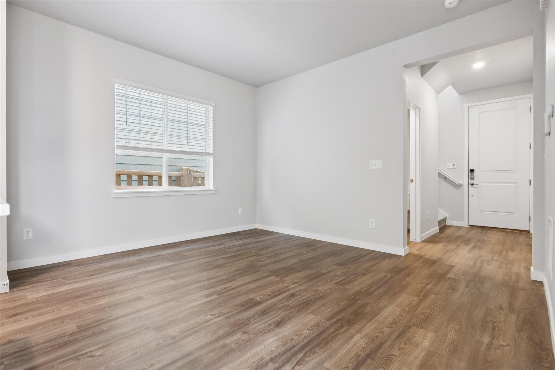 A room with a wood floor and white walls.