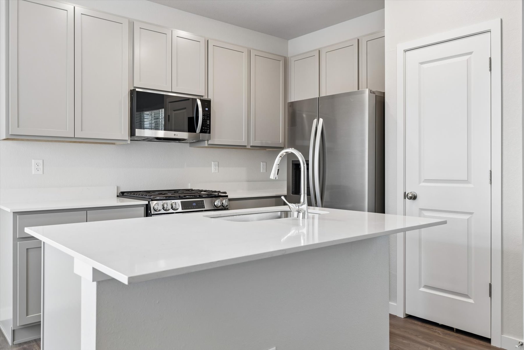 A kitchen with white cabinets.