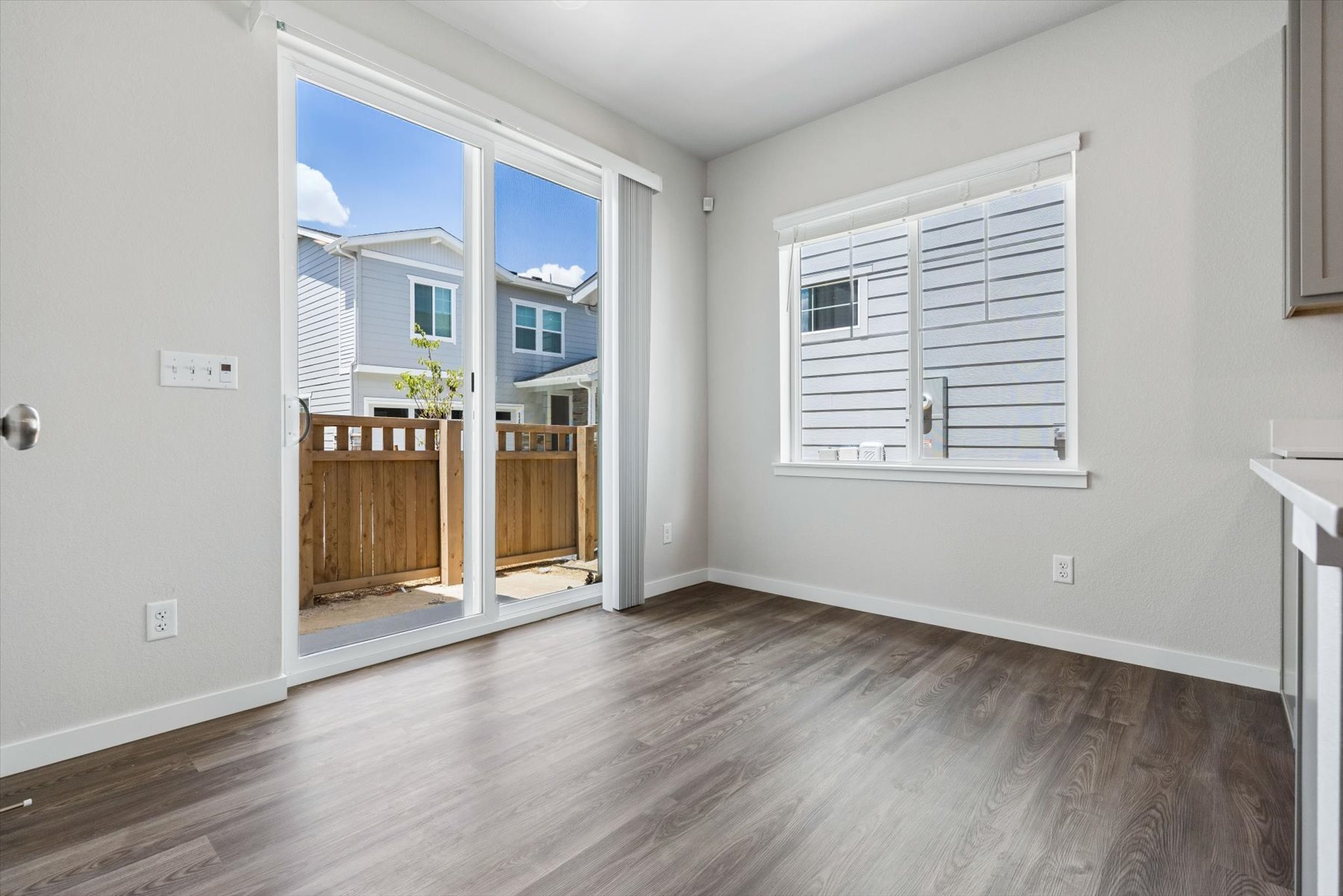 A room with a wood floor and a window with a view of the city.