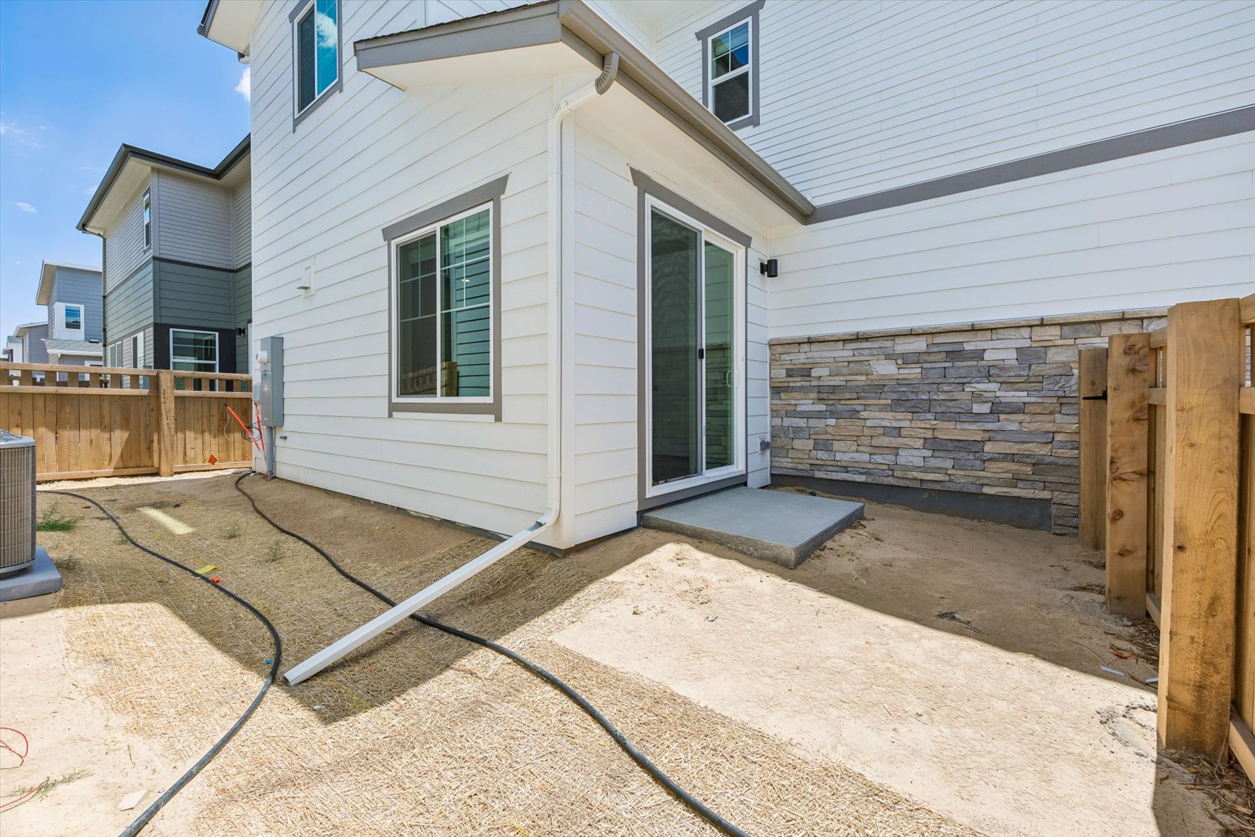 A house with a fence and a dirt yard.