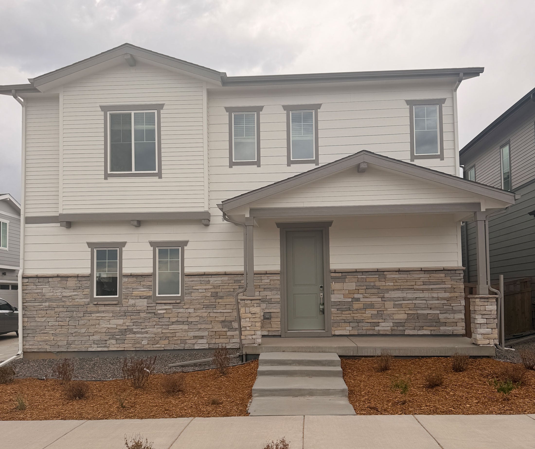 A grey house with a garage.