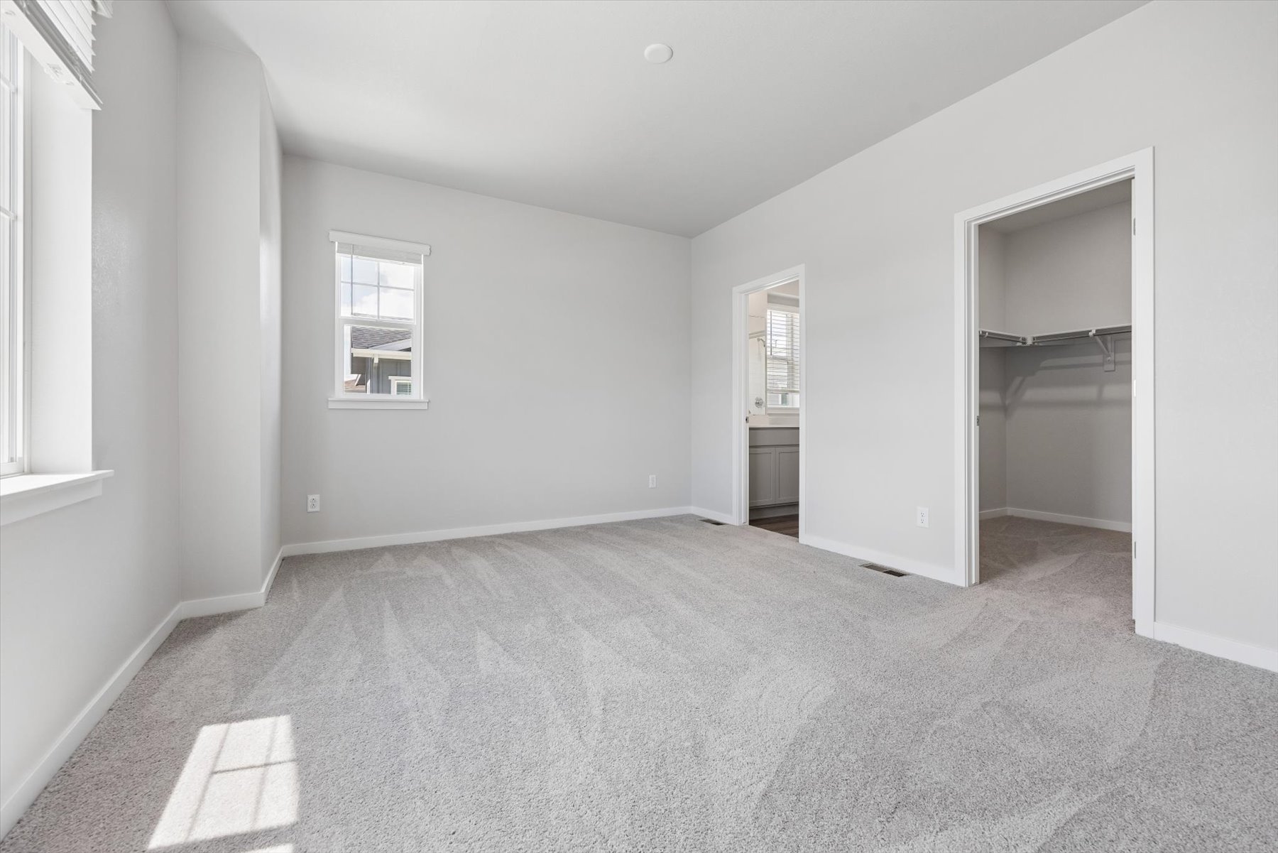 A room with a carpet and a window.