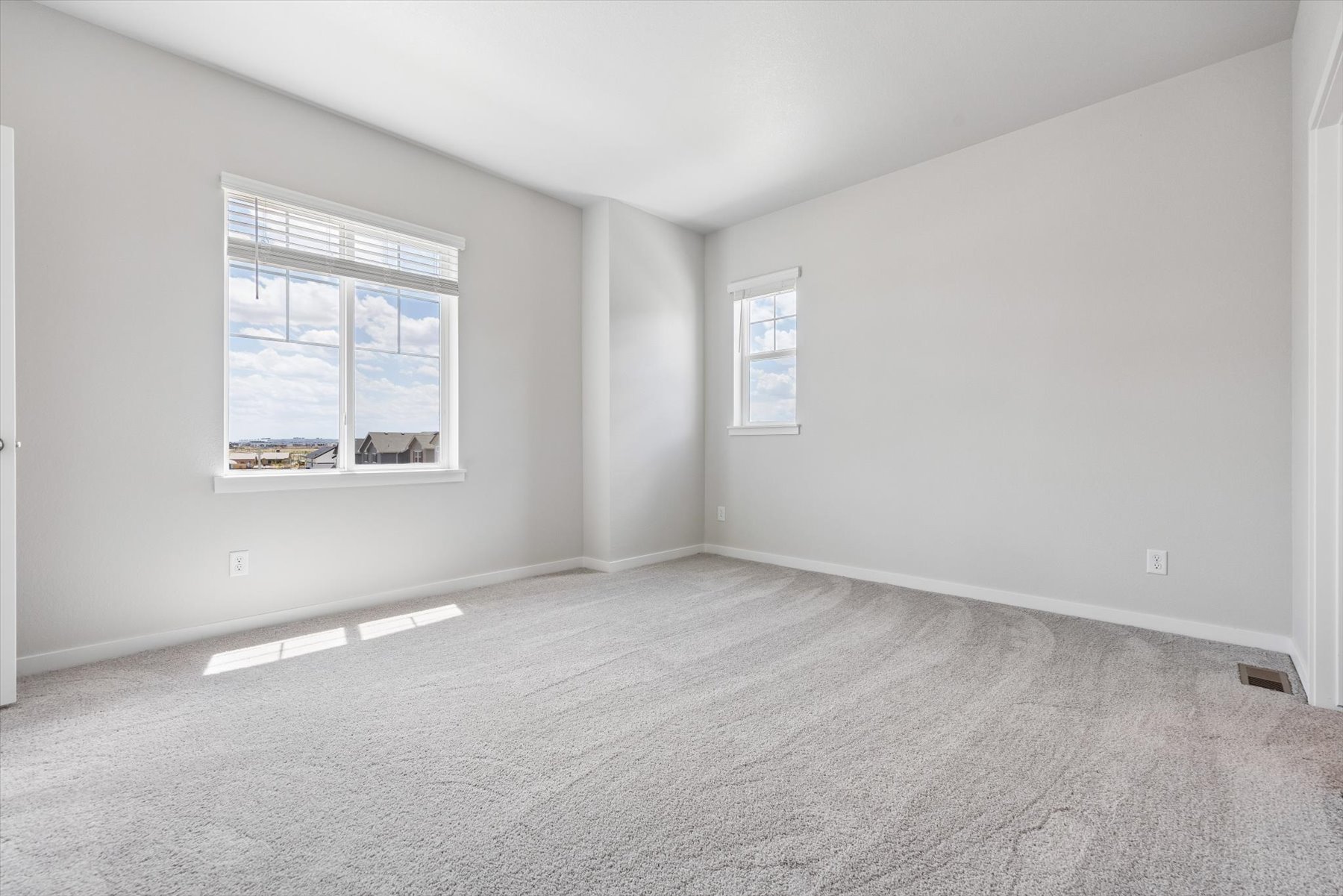 A room with a carpet and windows.