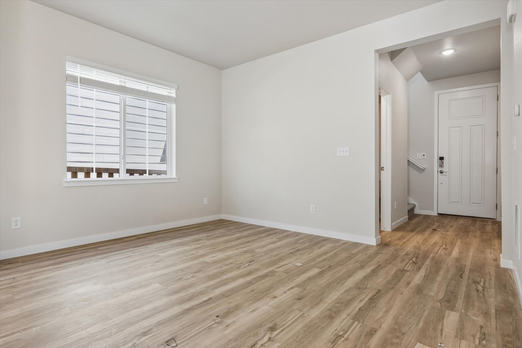 A room with a wood floor and a window.