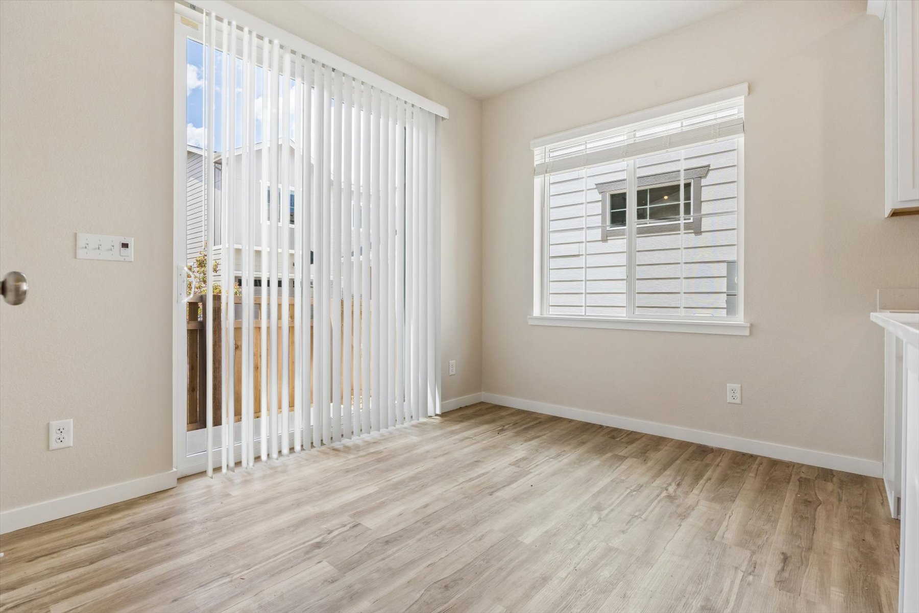 A room with a wood floor and a white window.
