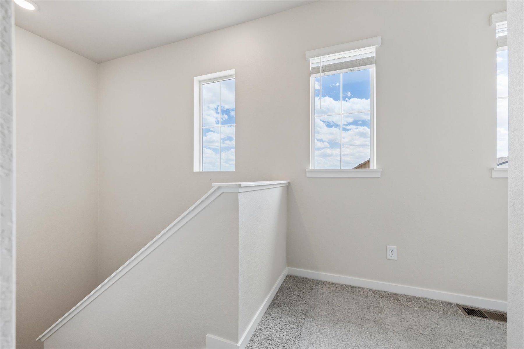 A room with a window and a white wall.