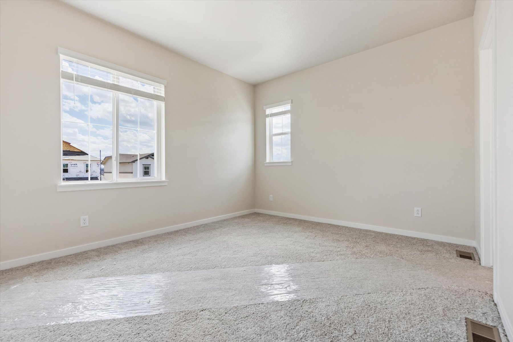 A room with a carpet and windows.