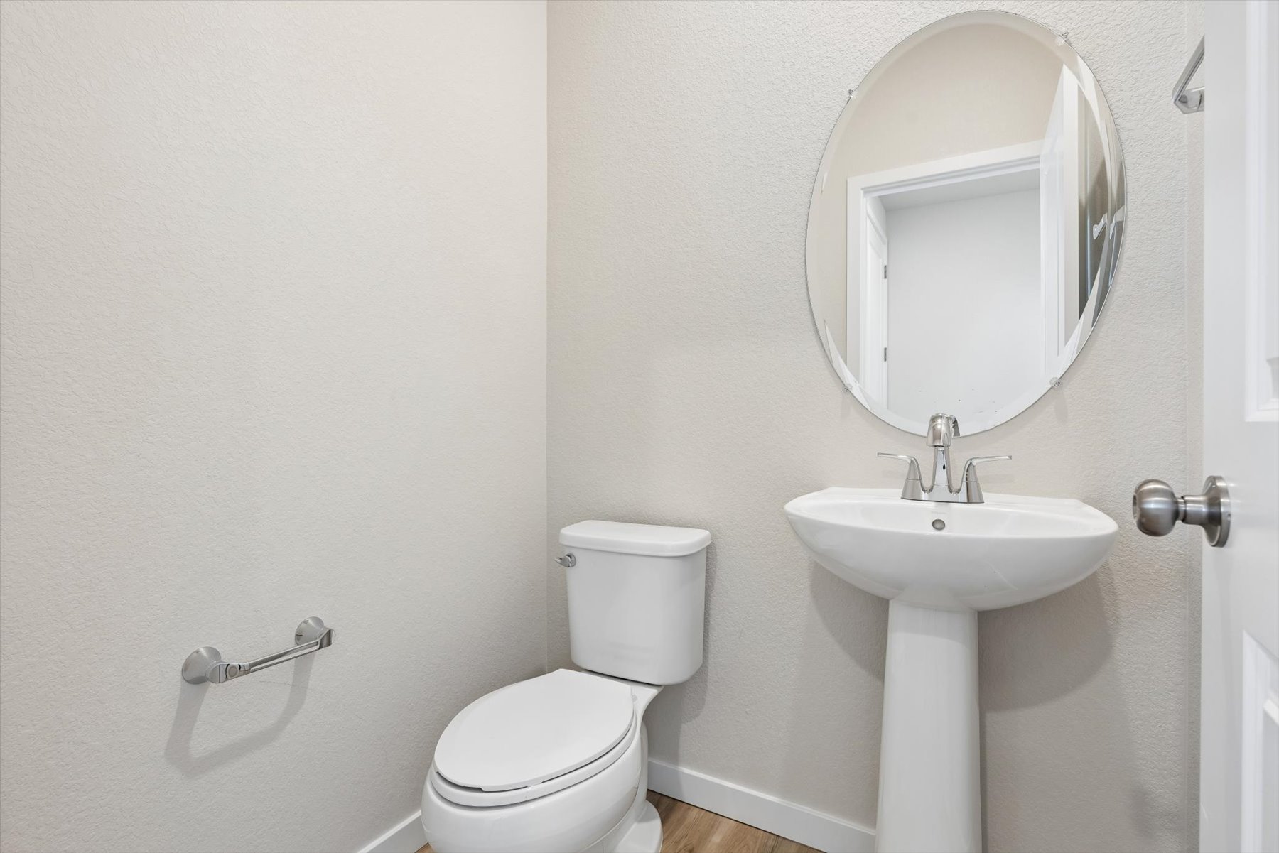 A bathroom with a round mirror.