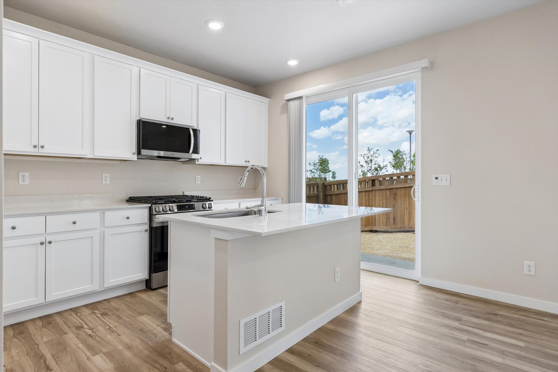 A kitchen with white cabinets.
