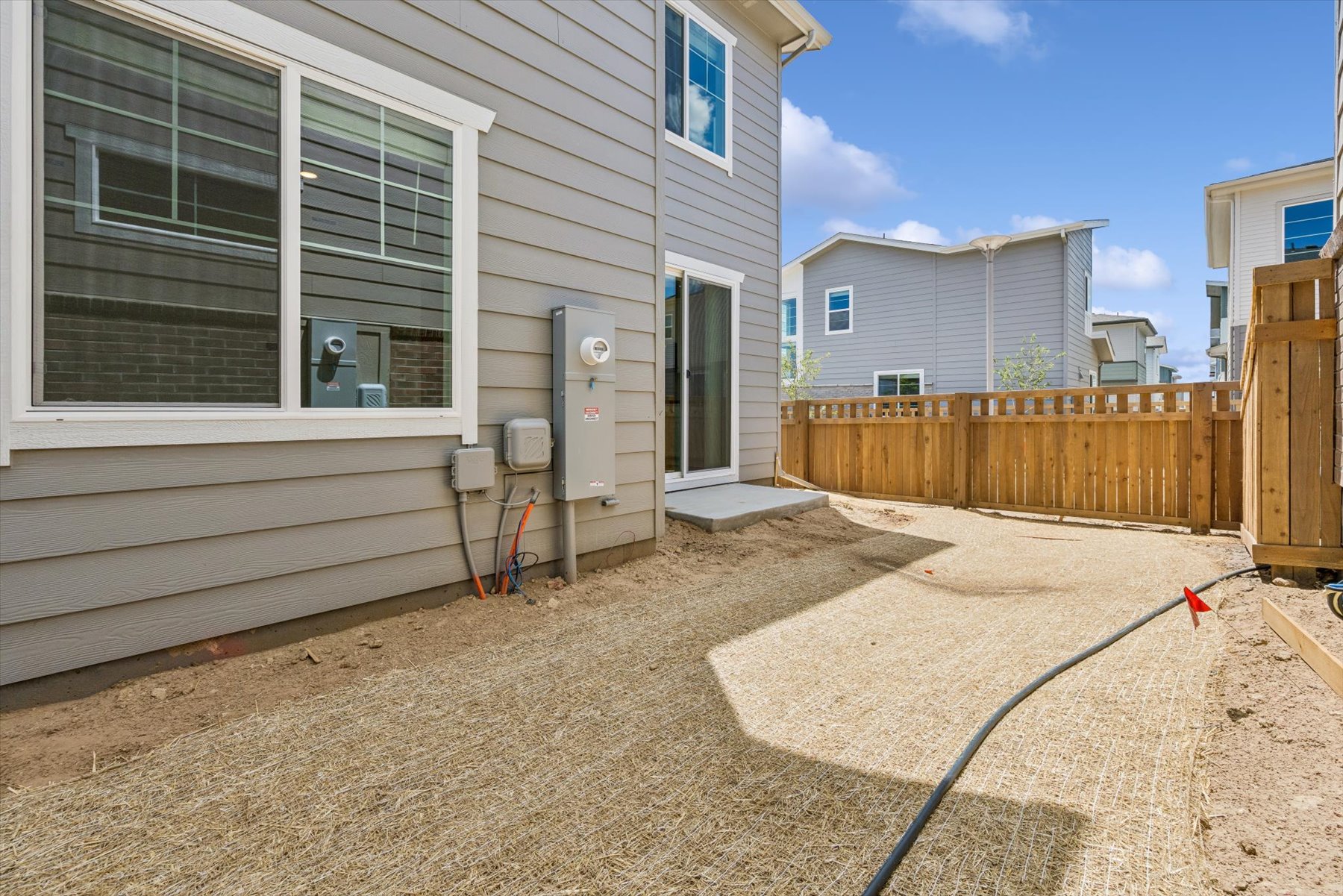 A house with a fence and a dirt yard.