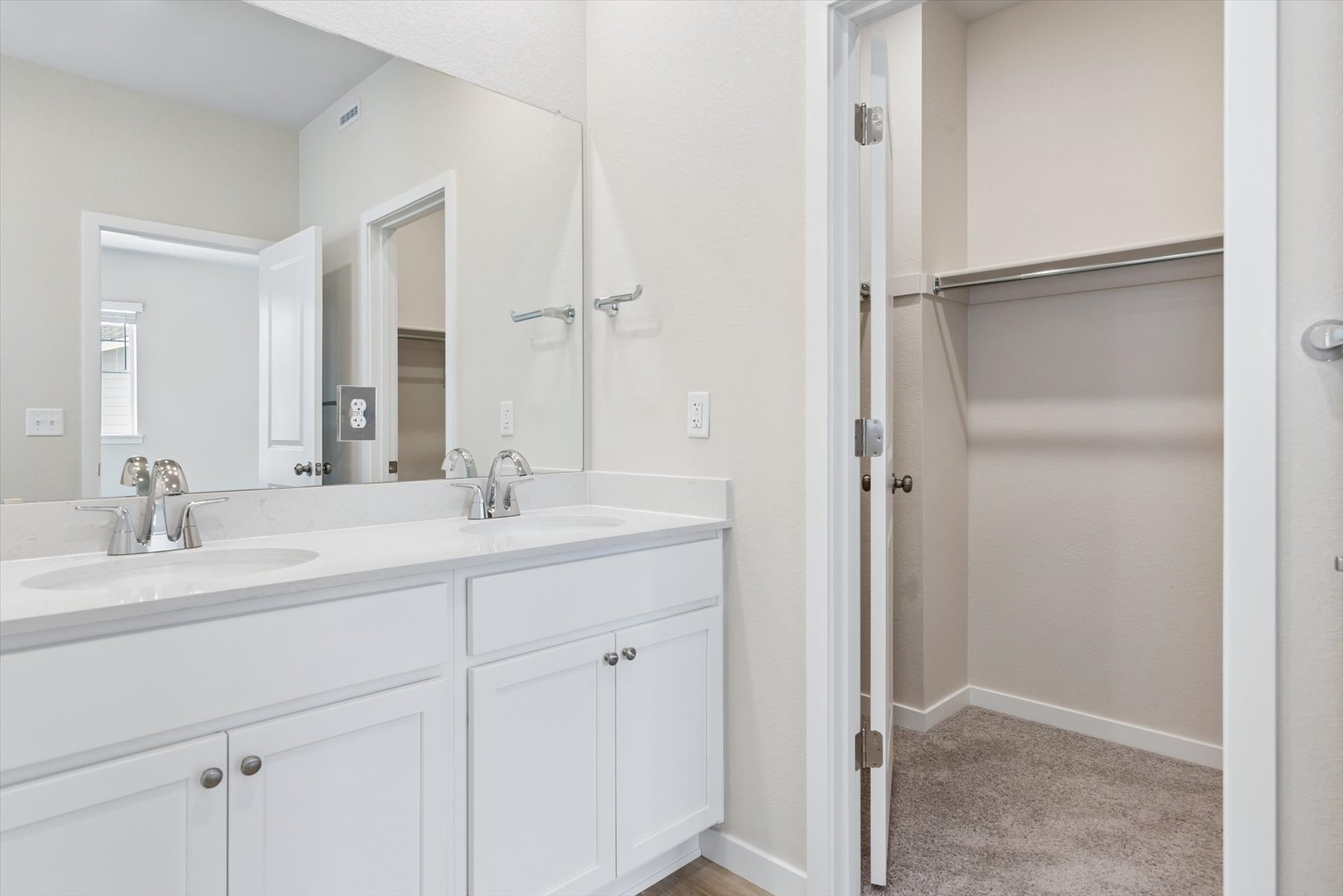 A bathroom with white cabinets.