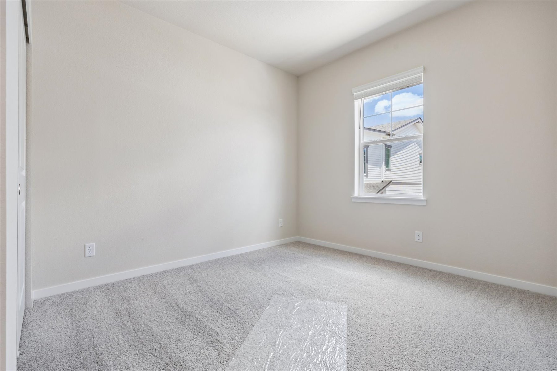 A room with a rug and a window.