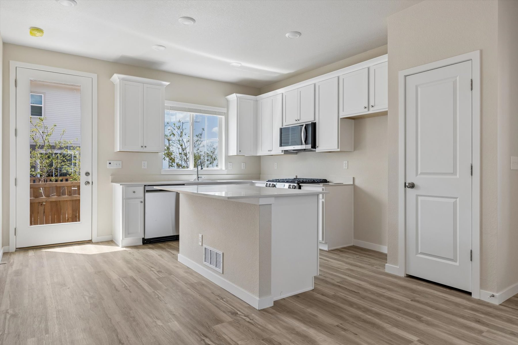 A kitchen with white cabinets.