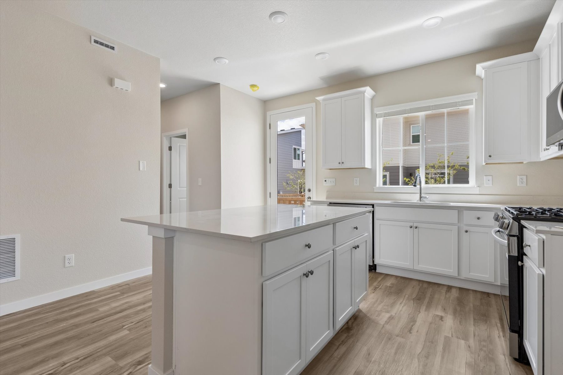 A kitchen with white cabinets.