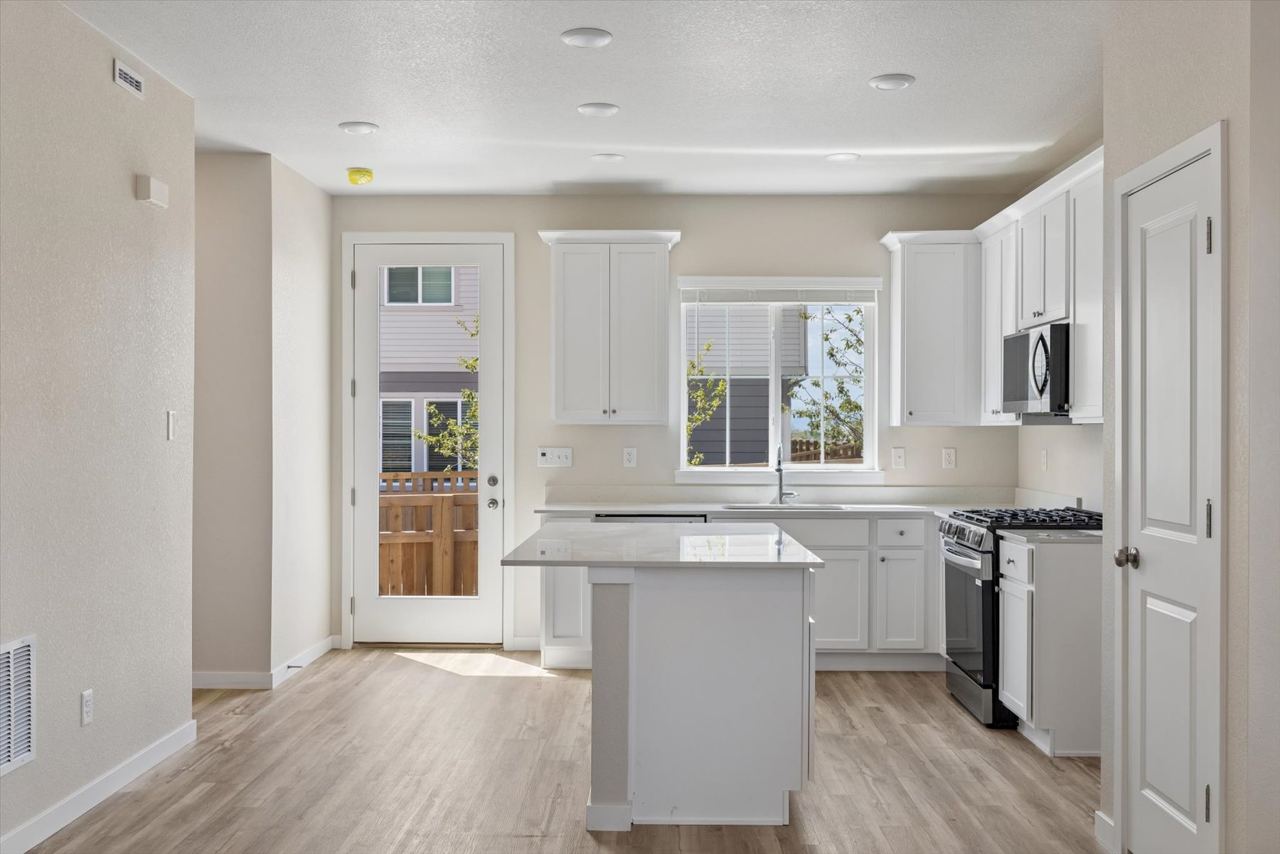 A kitchen with white cabinets.