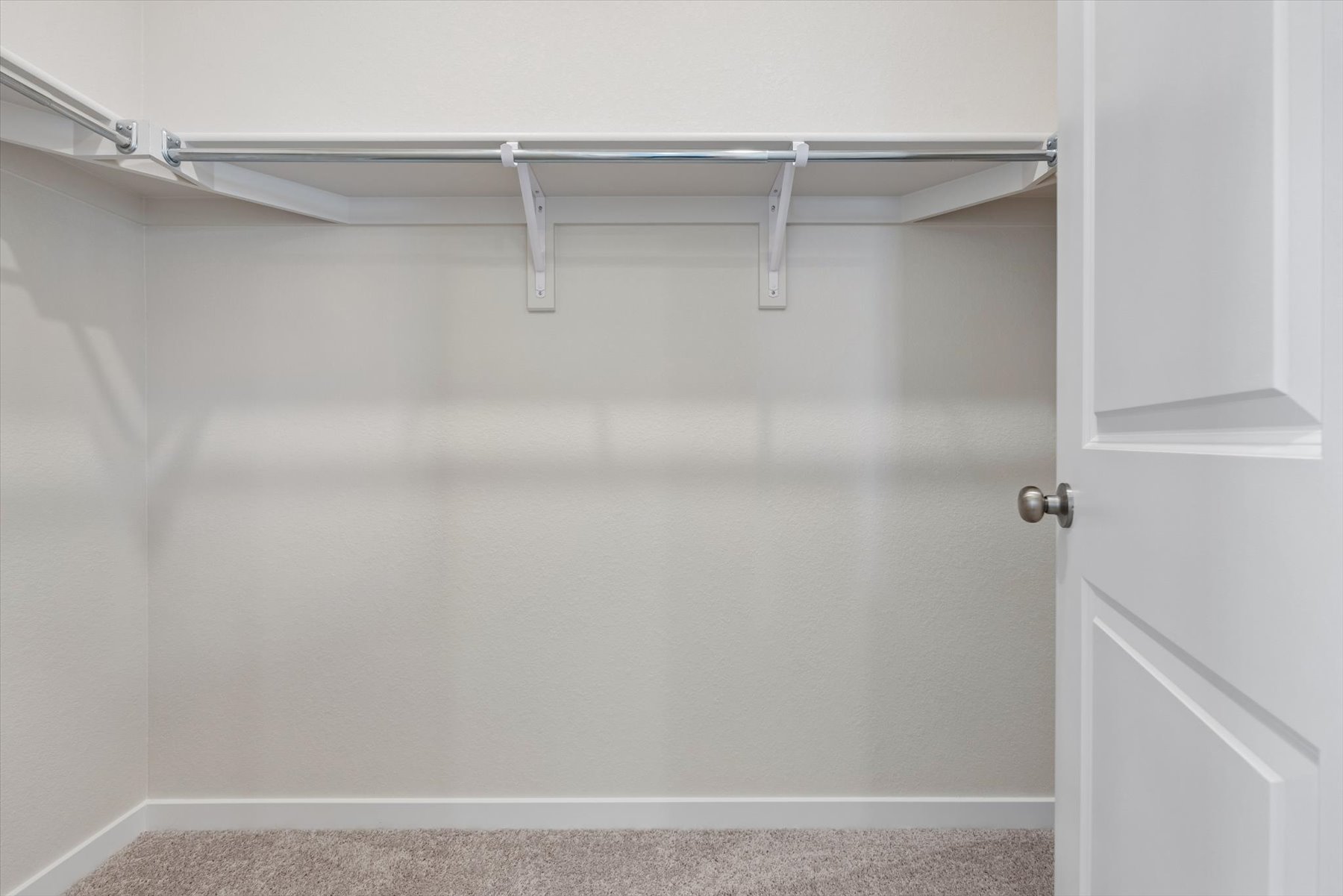 A white door with a metal bar.