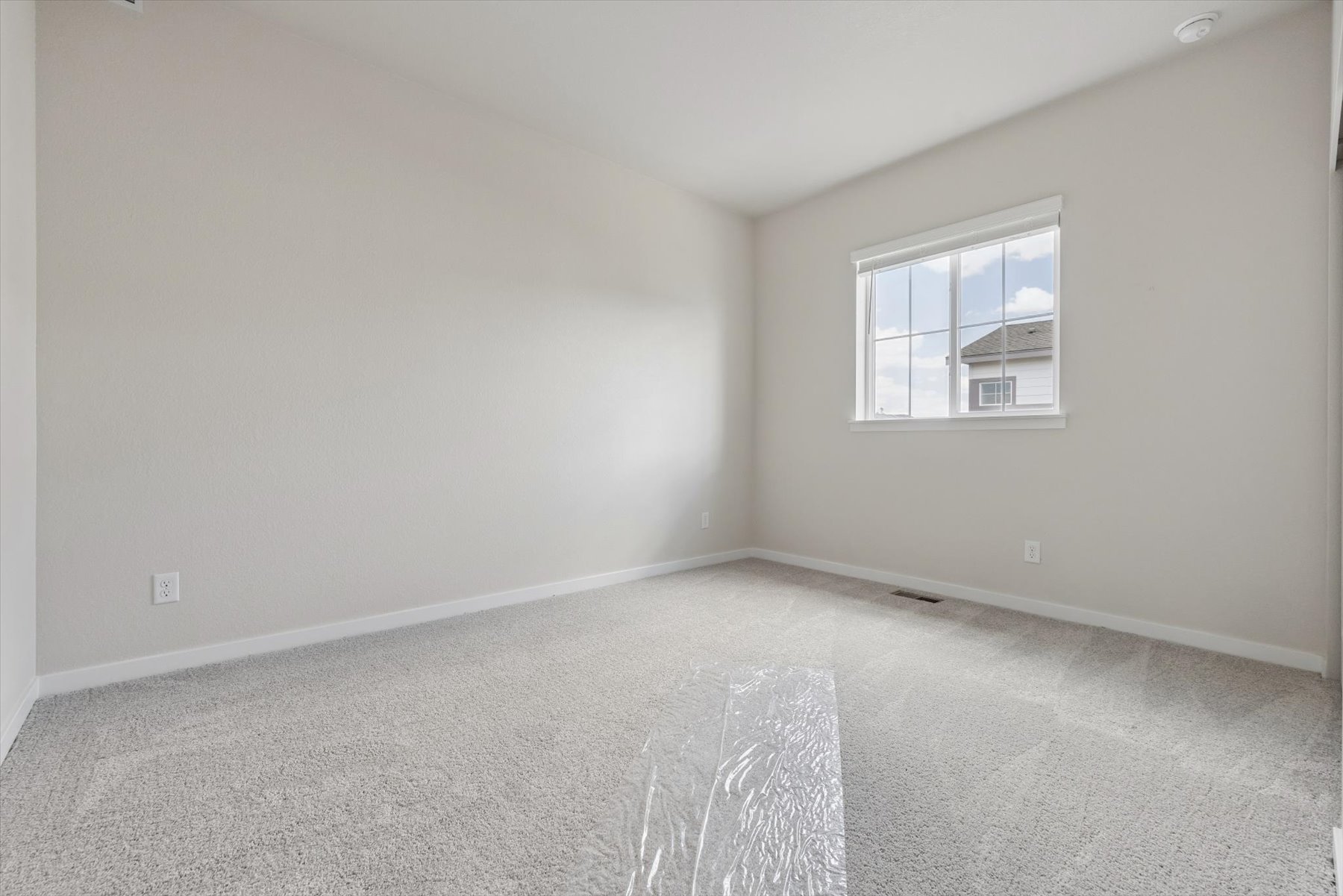 A room with a window and a carpet.