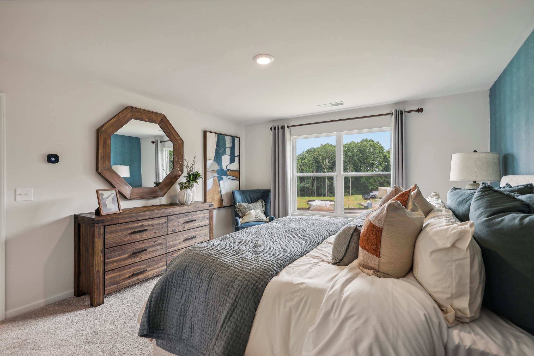 A bedroom with a large mirror.