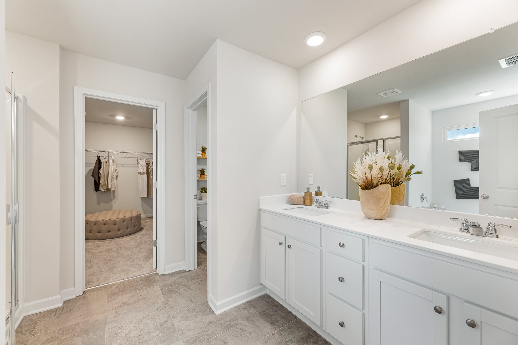 A bathroom with white cabinets.
