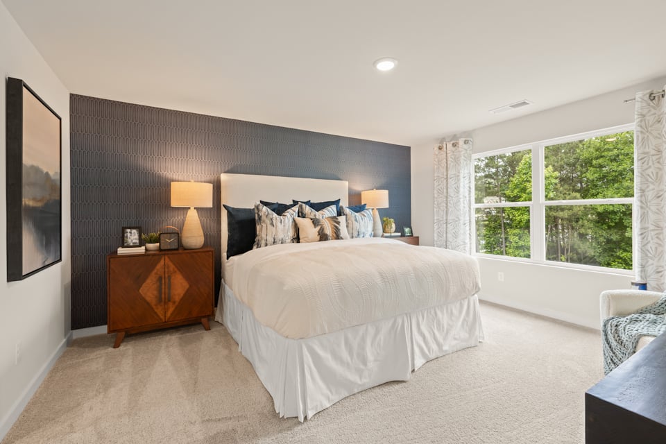 A bedroom with a bed and a window.