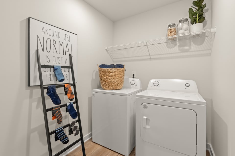A laundry room with a white laundry basket and a white laundry basket.