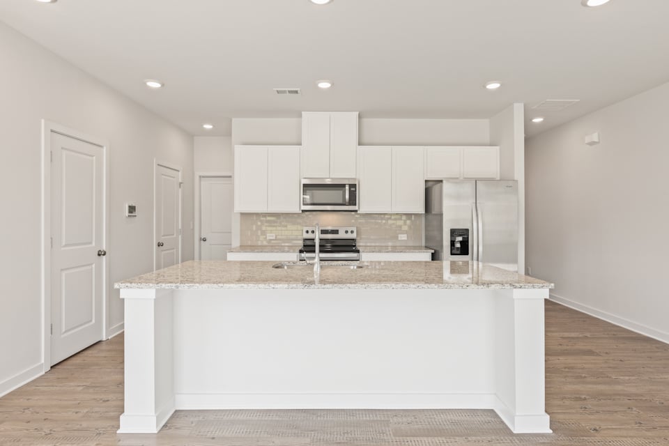 A kitchen with white cabinets.